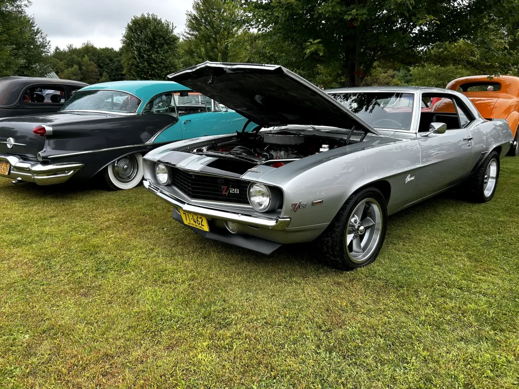 Silver classic Chevrolet Camaro with its hood open at Freddie’s Cruise-In 2024.
