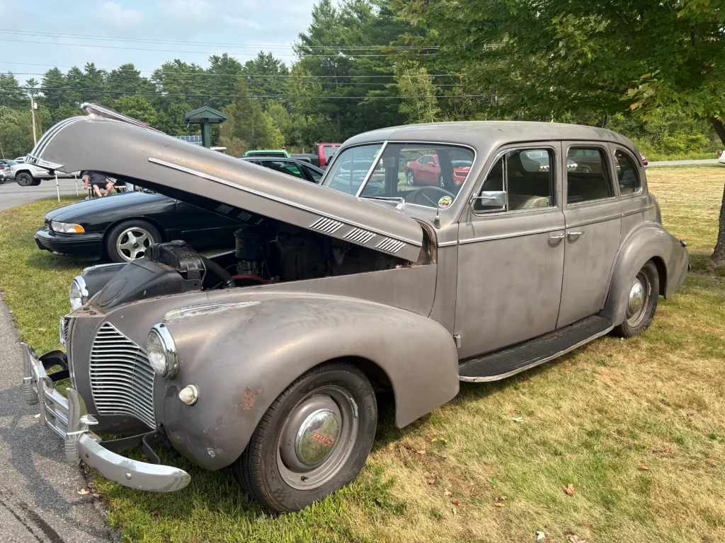 Gray 1938 Studebaker Commander four-door sedan with its hood open at Freddie's Cruise-In 2025.