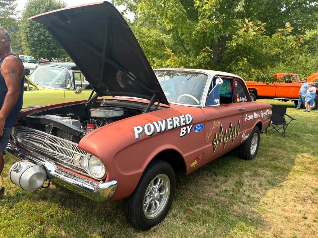 1960 Ford Falcon two-door sedan gasser with Acme Bros Speed Shop lettering and its hood open at Freddie's Cruise-In 2025.