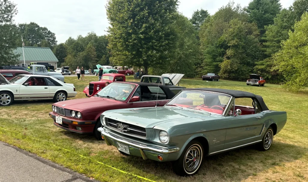 1966 Ford Mustang convertible beside a red 1987–1993 BMW 325i E30 convertible at Freddie's Cruise-In 2025.