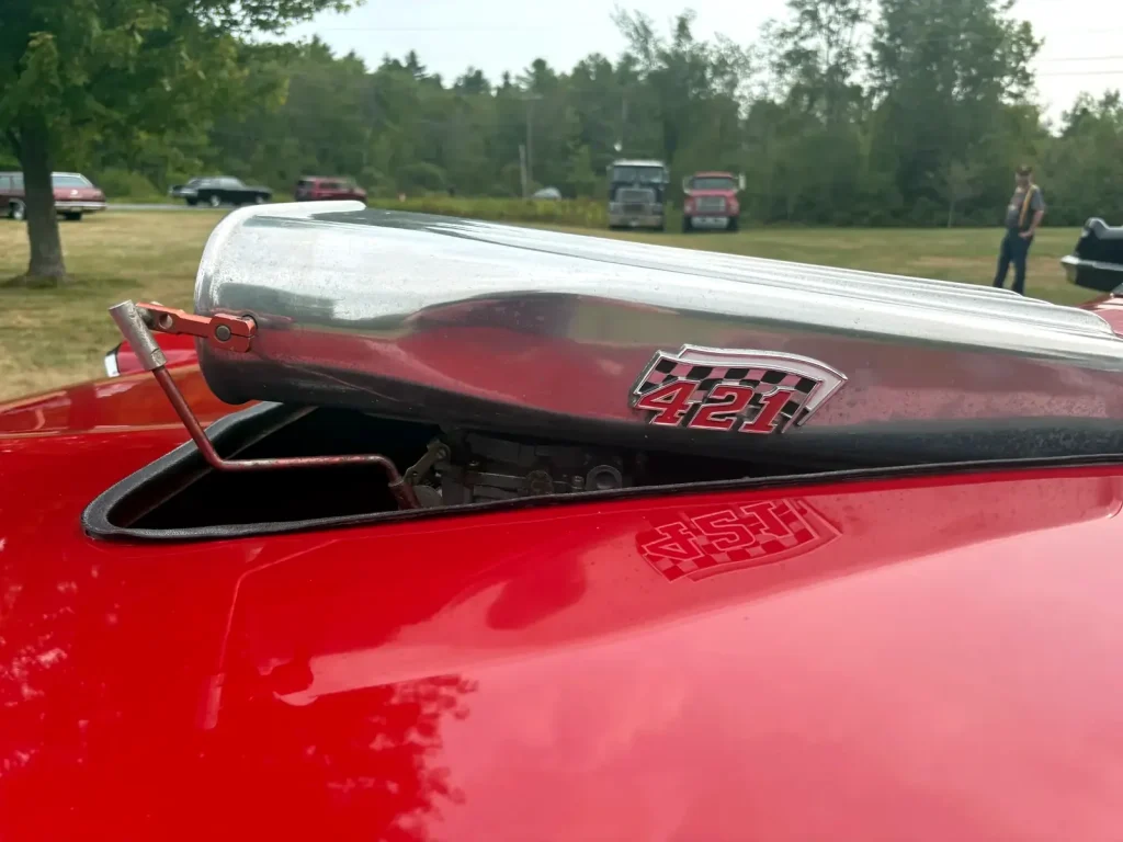 Close-up of a 421 engine identification badge on a red classic car at Freddie's Cruise-In 2025.