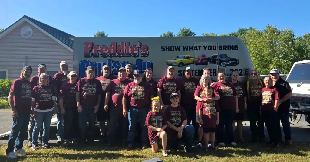 Staff, family members and volunteers gathered in front of the Freddie's Cruise-In trailer after the 2026 event.