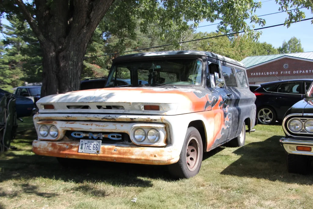 Patina GMC pickup displayed beneath the trees at Freddie's Cruise-In 2026 in Vassalboro, Maine.