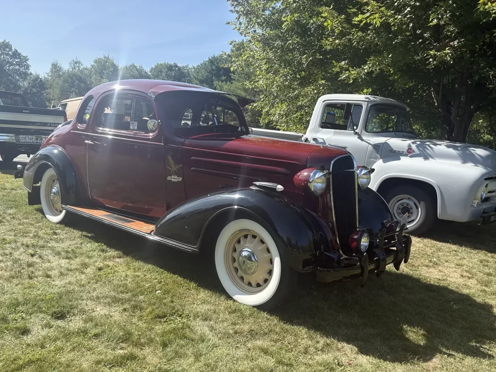 Two-tone vintage sedan displayed on the grass at Freddie's Cruise-In 2026 in Vassalboro, Maine.
