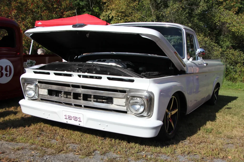 White customized Chevrolet pickup with its hood open at Freddie's Cruise-In 2026.